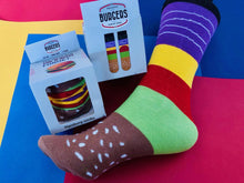 Load image into Gallery viewer, The socks are packed to actually look like a hamburger with all the fixings. Food socks that make a creative gift from Pomelo Socks. Back and front of Burger packaging is shown.
